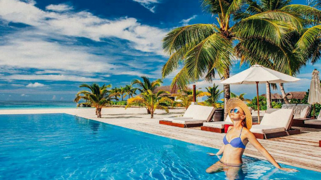 Imagen de Mujer disfrutando de un baño de piscina con el mar a la vista.