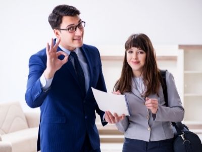 Asesor Inmobiliario Profesional firmando la venta de un departamento en Mérida y su cliente muy satisfecha por la asesoría recibida.